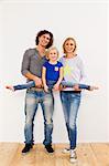 Studio portrait of couple holding up daughter