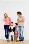 Studio shot of couple with son and daughter in oversize clothes