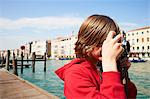 Young boy taking photographs on camera,Venice, Italy