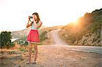 Girl taking photographs at sunset, Kas, Turkey