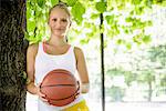 Portrait of young female basketball player in park