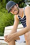 Portrait of young male basketball player sitting on park bench