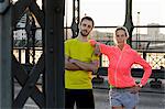 Portrait of young running couple on bridge