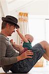 Father wearing hat with baby sitting on his lap