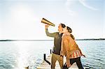 Couple using megaphone by lake