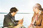 Couple by lake opening champagne