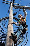 Cable lineman checking support wire tension for new cable installation