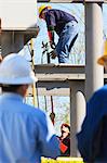 Power engineer handing an engineer a grounding strap while working on a high voltage distribution station