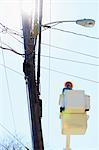 Power engineer riding in lift bucket to work on power lines, Braintree, Massachusetts, USA