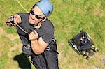 Man with spinal cord injury using adaptive climbing equipment for rock climbing