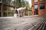 Man painting terrace dock, Ronneby, Blekinge, Sweden