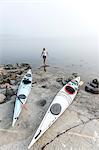 Woman resting near canoes, Sweden