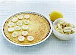 Placing the sliced bananas on the baked tart