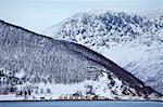 Homes and fishing huts  in hamlet across fjord from Sandneshamnvegen 862 on Kvaloya Island, Tromso, Arctic Circle, Northern Norway