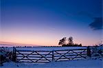 Farm gate in traditional snow scene in The Cotswolds, Swinbrook, Oxfordshire, United Kingdom