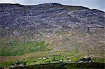 Homes nestling at the foot of the Maumturk mountain range near Recess in Connemara, County Galway, Ireland