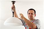 Electrician mounting ceiling lamp - closeup