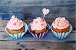 Photo of 3 cupcakes on wooden background