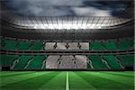 Digitally generated nigerian national flag against large football stadium