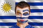Composite image of serious young uruguay fan with facepaint against digitally generated uruguay national flag