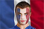 Composite image of serious young france fan with facepaint against digitally generated france national flag