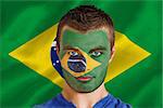 Composite image of serious young brasil fan with facepaint against digitally generated brazilian national flag