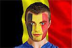 Composite image of serious young belgium fan with facepaint against belgium flag