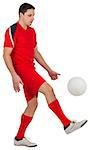 Fit young football player kicking on white background