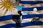 Football player in red kicking against digitally generated uruguay national flag