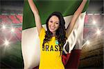 Excited football fan in brasil tshirt holding italy flag against vast football stadium with fans in yellow and red