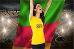Excited football fan in brasil tshirt holding cameroon flag against vast football stadium with fans in yellow