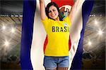Excited football fan in brasil tshirt holding costa rica flag against vast football stadium with fans in yellow