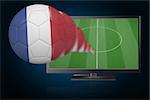 Football in france colours flying out of tv against blue background with vignette