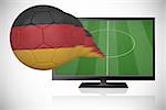 Football in germany colours flying out of tv against white background with vignette