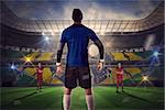 Composite image of goalie facing opposition against large football stadium with brasilian fans