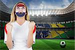 Excited netherlands fan in face paint cheering against large football stadium with brasilian fans