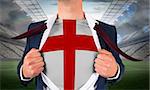 Businessman opening shirt to reveal england flag against large football stadium with lights