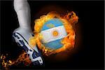 Football player kicking flaming argentina flag ball against black