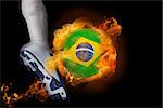 Football player kicking flaming brasil ball against black