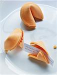 Close up of fortune cookies on white plate, showing text for long, happy life, studio shot