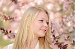 Portrait of Young Woman in front of Cherry Blossoms in Park in Spring, Franconia, Bavaria, Germany