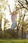 Close-up of Young Woman Jumping in the air in Park in Spring, Franconia, Bavaria, Germany