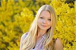 Portrait of Young Woman in front of Forsythia in Park in Spring, Franconia, Bavaria, Germany