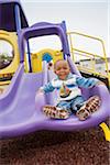 Portrait of Boy Playing on Playground Slide, Maryland, USA