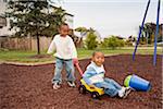 Boy Pulling Younger Brother in Wagon at Playground, Maryland, USA