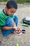 Crouching Boy Preparing Worm for Fishing, Lake Fairfax, Reston, Virginia, USA