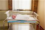 Newborn baby crying in hospital neonatal bassinet, Maryland, USA