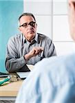 Senior, male doctor conferring with male patient in office, Germany