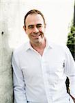 Portrait of man wearing white dress shirt outdoors, smiling and looking at camera, Germany