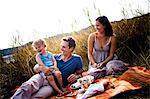 Young family with one child on the lakeside, having a picnic, Bavaria, Germany